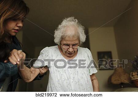 Stock Image - Granddaughter helping grandmother stand. Fotosearch
