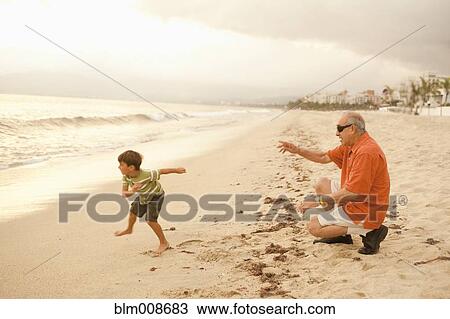 Grandfather and grandson playing on beach together View Large Photo Image Stock Image - Grandfather and grandson playing on beach together. Fotosearch