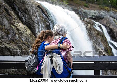 Grandmother and granddaughter admiring waterfall View Large Photo Image Picture - Grandmother and granddaughter admiring waterfall. Fotosearch