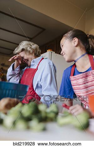 Stock Photo - Grandmother and granddaughter cooking in kitchen. Fotosearch