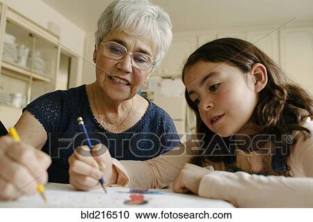 Grandmother and granddaughter drawing at table View Large Photo Image Stock Image - Grandmother and granddaughter drawing at table. Fotosearch
