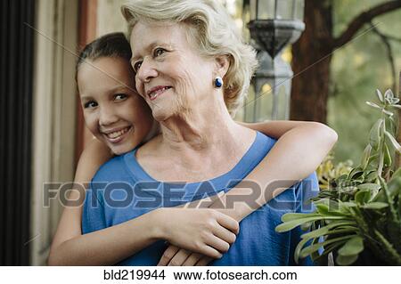 Grandmother and granddaughter hugging on porch View Large Photo Image Picture - Grandmother and granddaughter hugging on porch. Fotosearch