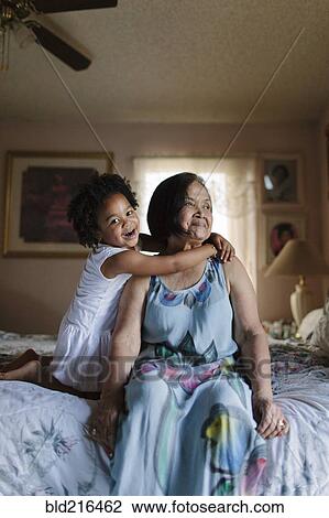 Grandmother and granddaughter hugging on bed View Large Photo Image Stock Image - Grandmother and granddaughter hugging on bed. Fotosearch