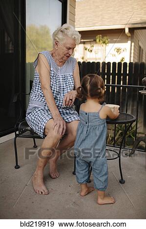 Grandmother and granddaughter playing on patio View Large Photo Image Stock Photo - Grandmother and granddaughter playing on patio. Fotosearch
