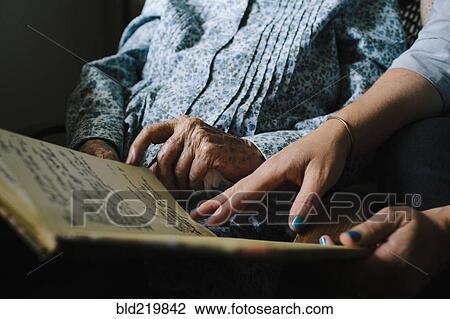Stock Image - Grandmother and granddaughter reading book. Fotosearch