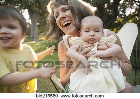 Grandmother playing with grandchildren in backyard View Large Photo Image Stock Image - Grandmother playing with grandchildren in backyard. Fotosearch