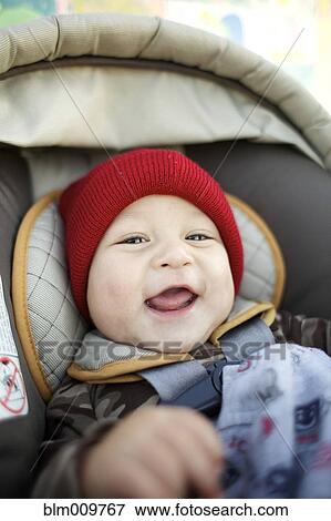 Stock Photo - Grinning mixed race baby in car seat. Fotosearch