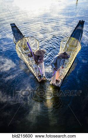 High angle view of Asian fishermen using fishing nets in canoe on river View Large Photo Image Stock Image - High angle view of Asian fishermen using fishing nets in canoe on river. Fotosearch