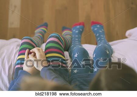 Stock Photo - High angle view of Caucasian sisters wearing colorful tights. Fotosearch