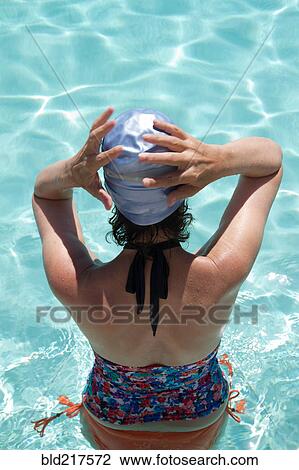 Stock Image - High angle view of Caucasian woman standing in pool. Fotosearch