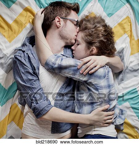 High angle view of cuddling couple on bed View Large Photo Image Stock Image - High angle view of cuddling couple on bed. Fotosearch