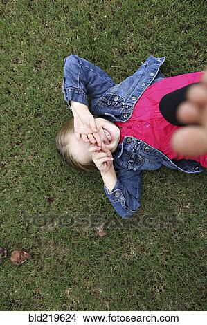 Picture - High angle view of girl laying in grass. Fotosearch