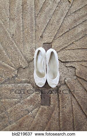 Stock Photo - High angle view of white high heel shoes on concrete. Fotosearch