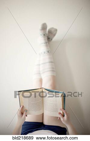 Stock Photo - High angle view of woman reading book. Fotosearch