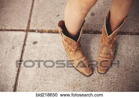 Stock Image - High angle view of woman wearing cowboy boots. Fotosearch