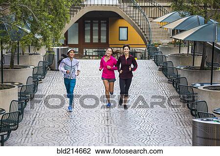 Stock Image - High angle view of women running in urban park. Fotosearch