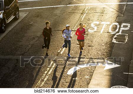 Stock Photograph - High angle view of women running in street. Fotosearch