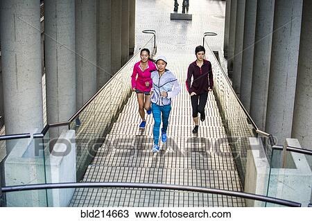 High angle view of women running on staircase View Large Photo Image Stock Image - High angle view of women running on staircase. Fotosearch