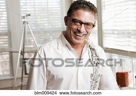 Picture - Hispanic artist standing in studio. Fotosearch