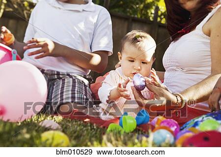 Hispanic baby playing with Easter eggs View Large Photo Image Stock Photo - Hispanic baby playing with Easter eggs. Fotosearch