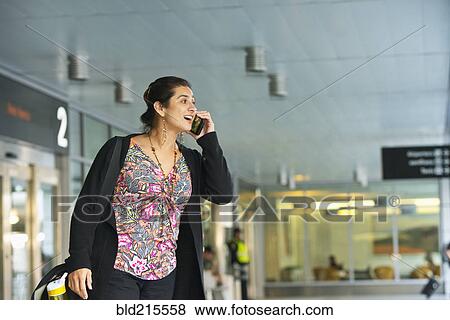 Hispanic businesswoman talking on cell phone in airport View Large Photo Image Stock Photo - Hispanic businesswoman talking on cell phone in airport. Fotosearch