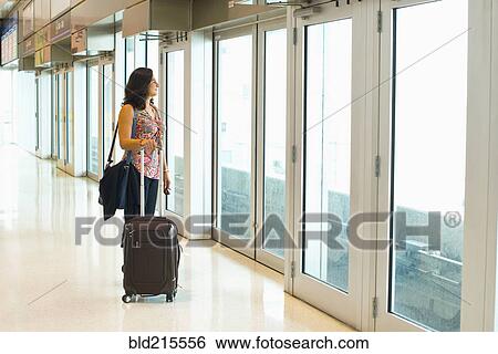 Stock Photograph - Hispanic businesswoman waiting in train station. Fotosearch