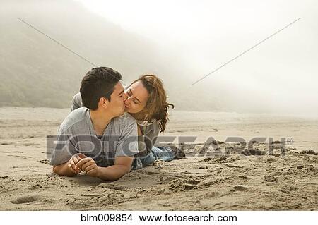 Picture - Hispanic couple kissing on beach. Fotosearch