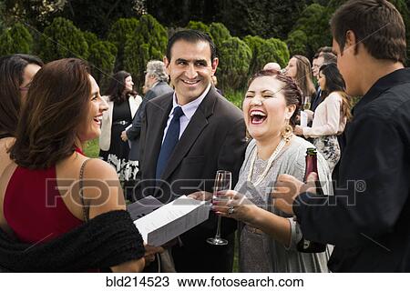 Stock Image - Hispanic family laughing at wedding. Fotosearch