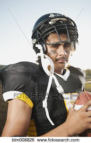 Hispanic football player holding football View Large Photo Image Stock Photograph - Hispanic football player holding football. Fotosearch
