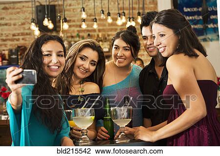 Hispanic friends taking selfie in bar View Large Photo Image Stock Image - Hispanic friends taking selfie in bar. Fotosearch