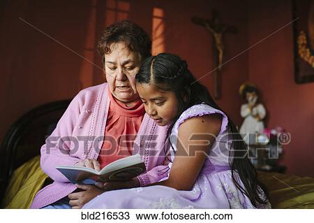 Hispanic grandmother and granddaughter reading book on bed View Large Photo Image Stock Image - Hispanic grandmother and granddaughter reading book on bed. Fotosearch
