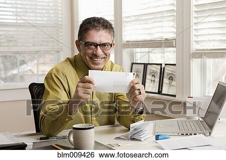 Stock Photograph - Hispanic man holding envelope. Fotosearch