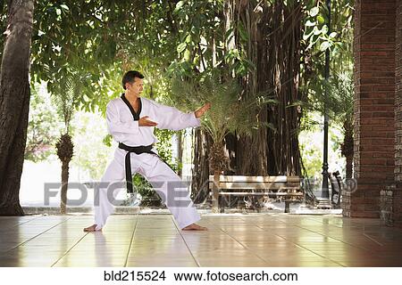 Hispanic man practicing martial arts on patio View Large Photo Image Picture - Hispanic man practicing martial arts on patio. Fotosearch