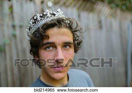Stock Photography - Hispanic man wearing crown in backyard. Fotosearch