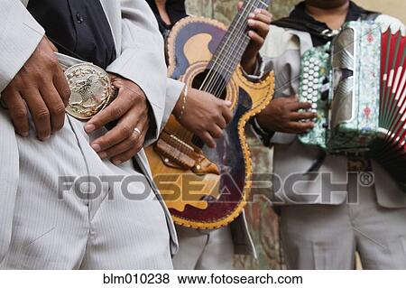Stock Photo - Hispanic men playing guitar and accordion. Fotosearch