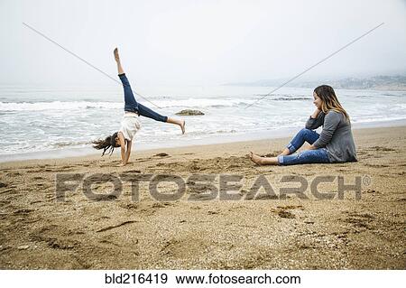 Stock Photo - Hispanic mother and daughter playing on beach. Fotosearch