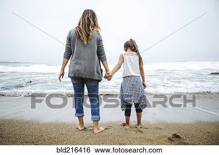 Hispanic mother and daughter standing barefoot on beach View Large Photo Image Stock Photograph - Hispanic mother and daughter standing barefoot on beach. Fotosearch