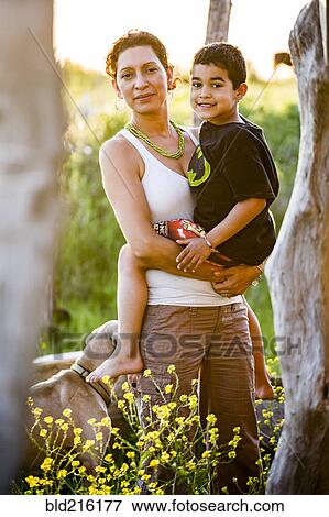 Hispanic mother carrying son in garden View Large Photo Image Stock Photo - Hispanic mother carrying son in garden. Fotosearch