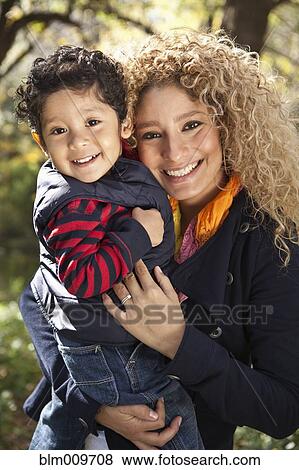 Hispanic mother holding son outdoors View Large Photo Image Stock Photo - Hispanic mother holding son outdoors. Fotosearch