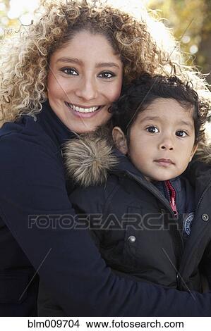 Picture - Hispanic mother hugging son. Fotosearch