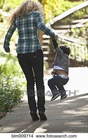 Hispanic mother lifting son in park View Large Photo Image Picture - Hispanic mother lifting son in park. Fotosearch