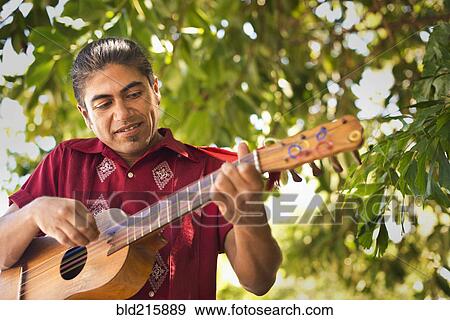 Stock Photo - Hispanic musician performing in park. Fotosearch