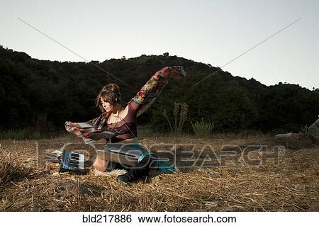 Stock Photograph - Hispanic musician playing keyboard in field. Fotosearch