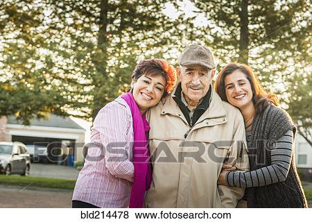 Stock Photo - Hispanic parents and daughter smiling outdoors. Fotosearch