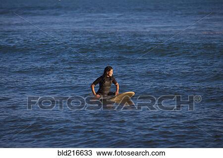 Hispanic surfer floating on surfboard in ocean View Large Photo Image Stock Image - Hispanic surfer floating on surfboard in ocean. Fotosearch
