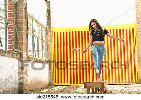 Stock Photography - Hispanic woman balancing on platform. Fotosearch
