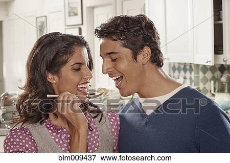 Stock Photo - Hispanic woman feeding husband. Fotosearch