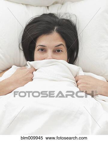Hispanic woman in bed covering her face View Large Photo Image Stock Photography - Hispanic woman in bed covering her face. Fotosearch