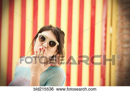 Hispanic woman in sunglasses blowing kisses View Large Photo Image Stock Photograph - Hispanic woman in sunglasses blowing kisses. Fotosearch