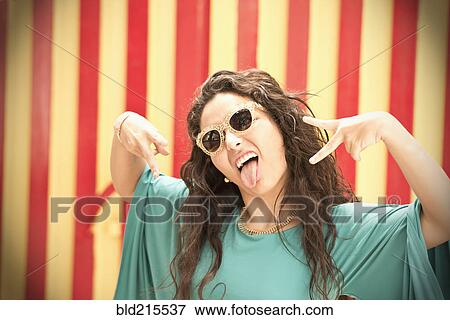 Stock Photo - Hispanic woman in sunglasses making a face. Fotosearch